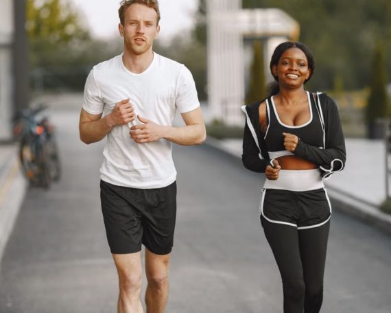 A man and woman jogging together outside, embracing a healthy lifestyle.